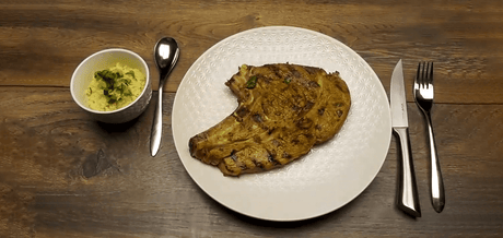 Côte de Veau à la Chermoula sur une assiette blanche accompagnée d'une sauce maison
