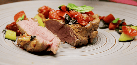 Tranche de veau à la tomate basilic sur une assiette grise