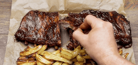 Travers de Porc à la Texane accompagné de frites maison sur une plaque en bois